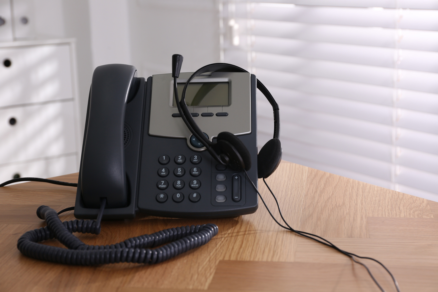 Stationary Phone and Headset on Wooden Table Indoors. Hotline Service
